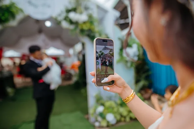 Une invitée photographie une scène de la fête avec son smartphone